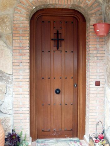 puerta de exterior rodeada por ladrillos hecha por Carpintería Arce